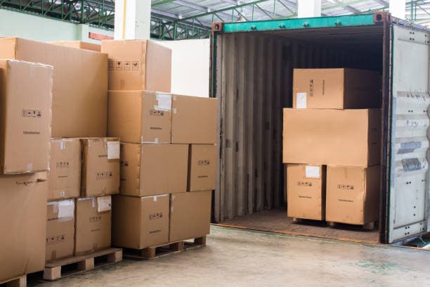 Cartons loading out of shipping container representing business operations